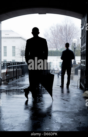 Il Presidente Usa Barack Obama attende una pioggia pesante a passare prima di attraversamento ovest Viale esecutivo da Eisenhower Executive Office edificio all'ala ovest della Casa Bianca Marzo 12, 2013 a Washington, DC. Foto Stock