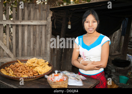 Giovane donna vendita alimentari, Yay Kyi village, Mandalay Myanmar (Birmania) Foto Stock