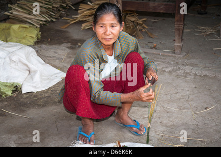 Donna di bambù di taglio per effettuare una ventola, Yay Kyi village, Mandalay Myanmar (Birmania) Foto Stock