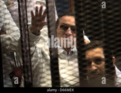 Aprile 13, 2013 - Cairo, Egitto - Ex presidente egiziano Hosni Mubarak onde da dietro le sbarre in aula durante il suo processo. Mubarak è arrivato in Accademia di polizia al Cairo la periferia per la sua riapertura del processo il sabato mattina, solo per avere il giudice di supervisionare il processo di dimettersi improvvisamente. (Credito Immagine: © Tareq Gabas APA/images/ZUMAPRESS.com) Foto Stock