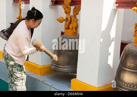 La donna lo squillo di una campana, Mahamuni Pagoda, Mandalay, Myanmar (Birmania) Foto Stock