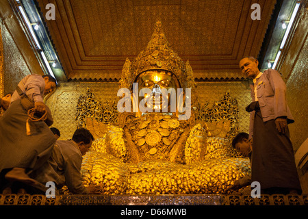 Adoratori di applicare la foglia di oro per il Buddha Mahamuni, Mahamuni Pagoda, Mandalay, Myanmar (Birmania) Foto Stock