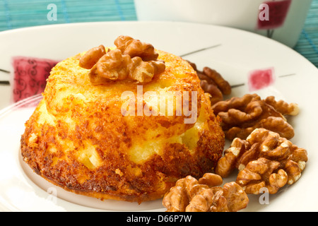 Formaggio muffin con noci su una piastra con tè Foto Stock