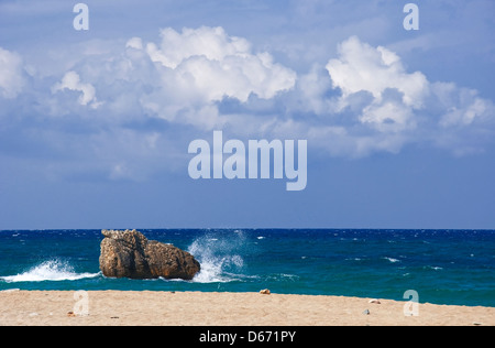 Onde che si infrangono sulla roccia sulla spiaggia solitaria Foto Stock