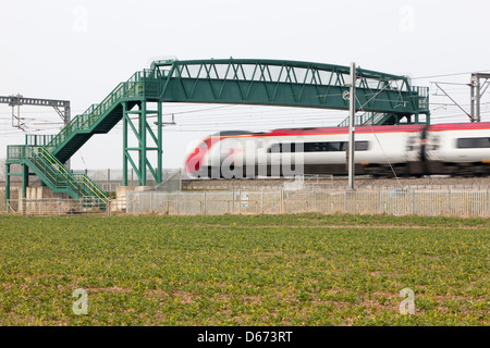 Un treno vergine passando sotto un cavalcavia sulla West Coast Mainline. Foto Stock