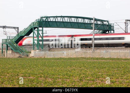 Un treno vergine passando sotto un cavalcavia sulla West Coast Mainline. Foto Stock