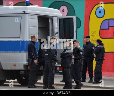 Gli ufficiali di polizia stare vicino alla East Side Gallery di Berlino, Germania, 14 aprile 2013. Un investitore piani per la costruzione di un alto edificio di appartamenti su un terreno vicino al fiume Sprea. Una protesta contro questi piani è stata messa in scena il 14 aprile 2013. Foto: BRITTA PEDERSEN Foto Stock
