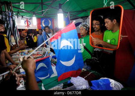 Aprile 14, 2013 - Kuala Lumpur, Malesia - i sostenitori del Malaysian partito di opposizione, particol Keadilan Rakyat (Persone giustizia partito) acquistare mercanzie durante una campagna elettorale rally in anticipo del XIII prossime elezioni generali in Kuala Lumpur. Malaysia il 10 aprile ha annunciato le elezioni generali di Maggio 5, impostando una lunga attesa data per sondaggi con punta a essere la più vicina mai come la lunga-pregiudiziale governo cerca di tenere a bada un pendolamento opposizione. (Credito Immagine: © Najjua Zulkefli/ZUMAPRESS.com) Foto Stock