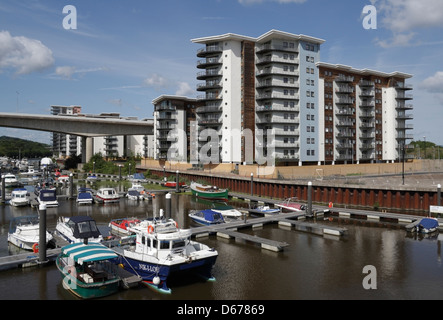 Barche ormeggiate nel fiume Ely nella baia di Cardiff, Galles, Regno Unito, insieme a edifici residenziali di alto livello Foto Stock