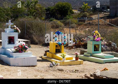 Colorate pietre di testa mark tombe decorate con fiori di imitazione in un cimitero di Todos Santos, Messico. Foto Stock