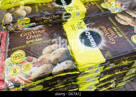 Una pila di sacchi di crescere in un garden center utilizzati per la coltivazione di patate o altri ortaggi a radice Foto Stock