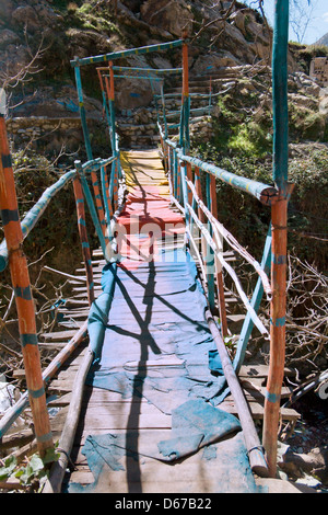 Sgangherato vecchio ponte di legno sul fiume nell'Ourika Valley, Marocco. Foto Stock