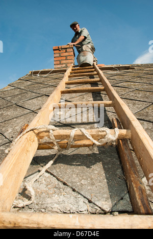 L uomo sulla scala la riparazione di camino, Polonia, Europa Foto Stock
