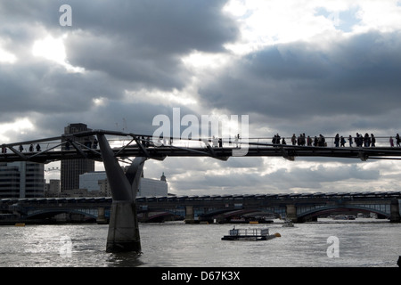 Una vista laterale di stagliano pedoni camminando sul Millennium Bridge sul fiume Tamigi Londra KATHY DEWITT Foto Stock