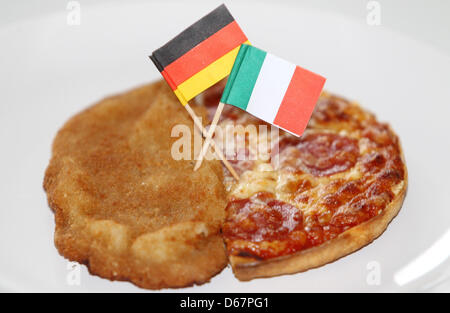 Illustrazione - Un foto illustrato mostra una cotoletta con una bandiera italiana e una pizza con una bandiera tedesca su una piastra ad Amburgo, Germania, 26 giugno 2012. La Germania dovrà svolgere in Italia in semifinale di Euro 2012 a Varsavia il 28 giugno 2012. Foto: Malte cristiani Foto Stock