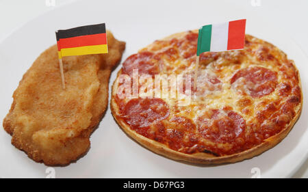 Illustrazione - Un foto illustrato mostra una cotoletta con una bandiera tedesca e una pizza con una bandiera italiana su una piastra ad Amburgo, Germania, 26 giugno 2012. La Germania dovrà svolgere in Italia in semifinale di Euro 2012 a Varsavia il 28 giugno 2012. Foto: Malte cristiani Foto Stock