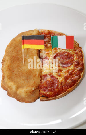 Illustrazione - Un foto illustrato mostra una cotoletta con una bandiera tedesca e una pizza con una bandiera italiana su una piastra ad Amburgo, Germania, 26 giugno 2012. La Germania dovrà svolgere in Italia in semifinale di Euro 2012 a Varsavia il 28 giugno 2012. Foto: Malte cristiani Foto Stock