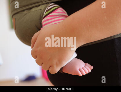 La mano di una madre e i piedi del suo bambino sono illustrati durante la formazione Kanga a Berlino (Germania), 22 giugno 2012. Kanga training è un nuovo allenamento consentendo alle madri di esercitare con i loro neonati vicino a loro. Trasportare i bimbi in una fionda bambino o del gestore per la maggior parte del tempo, le mamme si impegnano in endurance, indietro, pavimento pelvico, e muscolatura addominale della formazione. Foto: Jens Kalae Foto Stock