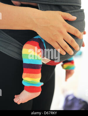 La mano di una madre e i piedi del suo bambino sono illustrati durante la formazione Kanga a Berlino (Germania), 22 giugno 2012. Kanga training è un nuovo allenamento consentendo alle madri di esercitare con i loro neonati vicino a loro. Trasportare i bimbi in una fionda bambino o del gestore per la maggior parte del tempo, le mamme si impegnano in endurance, indietro, pavimento pelvico, e muscolatura addominale della formazione. Foto: Jens Kalae Foto Stock