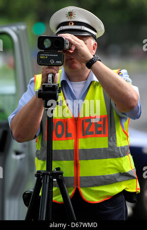 Un funzionario di polizia misura la velocità delle vetture con una velocità del laser gun a Duesseldorf in Germania, 29 giugno 2012. Il 03 luglio 2012 la polizia potrà effettuare la sua seconda velocità maratona di controllo. I cittadini del Land Renania settentrionale-Vestfalia sono stati coinvolti nella decisione dove impostare i comandi della velocità. Foto: Marius Becker Foto Stock