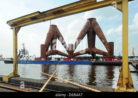 Due cavalletti di sedersi su un pontone mobile di "Offshore BHV 1' in corrispondenza di un molo di Siag cantieri di Emden, Germania, 04 luglio 2012. Il primo treppiedi saranno trasportati da 'Nordseewerke' cantieri navali per l'energia eolica produttore della turbina eolica 'Weserwind' in Bremerhaven poco. Essi diverranno allora le basi per turbine eoliche offshore wind farm 'Borkum-West'. Foto: INGO WAGNER Foto Stock