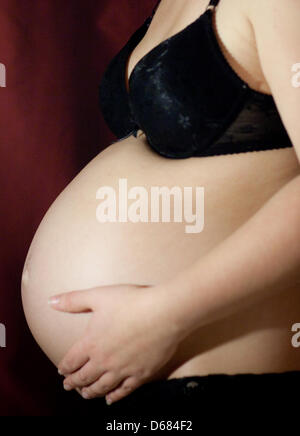 Attenzione la condizione di embargo 04 luglio 07:00 - (FILE) un archivio foto datata 02 dicembre 2009 mostra una donna in stato di gravidanza che mostra il suo stomaco a Francoforte sull'Oder, Germania. Solo un campione di sangue della donna incinta è necessario analizzare il corredo genetico di un bambino non ancora nato, secondo gli scienziati californiani. Un secondo gruppo statunitense ha presentato nozioni di base di un test che è in grado di dire se il bambino w Foto Stock