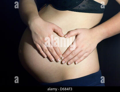 Attenzione la condizione di embargo 04 luglio 07:00 - (FILE) un archivio foto datata 02 dicembre 2009 mostra una donna in stato di gravidanza che mostra il suo stomaco a Francoforte sull'Oder, Germania. Solo un campione di sangue della donna incinta è necessario analizzare il corredo genetico di un bambino non ancora nato, secondo gli scienziati californiani. Un secondo gruppo statunitense ha presentato nozioni di base di un test che è in grado di dire se il bambino w Foto Stock