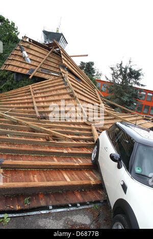 I dipendenti di auto Servizio di traino recuperare un auto dalle macerie di un tetto a Memmingen, Germania, 06 luglio 2012. Forti tempeste aveva portato via il tetto di un edificio amministrativo a Memmingen airport, che poi danneggiato diverse vetture. Foto: Karl-Josef Hildenbrand Foto Stock