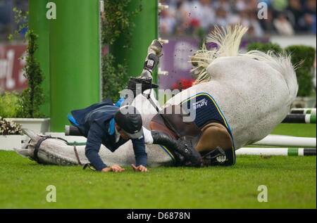 Svedese di dressage rider Peder Fredricson e il suo cavallo Arctic Aurora boreale cadono su di un ostacolo durante le qualifiche per la Coppa delle Nazioni a chio di Aachen, Germania, 05 luglio 2012. Foto: UWE ANSPACH Foto Stock