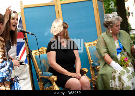 Una Donna vestita come la regina Elisabetta (R) e una donna che indossa una maschera di Camilla, duchessa di Cornovaglia (M), per prendere parte alla "Regine" di colata durante il castello di Celle festival presso il parco del castello in Celle, Germania, 07 luglio 2012. Il 'Regine Casting' premia il miglior costume e la conoscenza della famiglia reale britannica. Questa estate, le forze britanniche saranno lasciando la guarnigione città dopo la bei Foto Stock