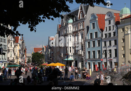 (Dpa-file) - Un file immagine datata 11 luglio 2011 mostra i turisti attraversando a piedi la piazza universitaria e Boulevard Kroepeliner Strasse nel centro della città di Rostock, Germania. Il kroepeliner Strasse a Rostock è una delle più famose aree per lo shopping della parte orientale della Germania. Foto: Bernd Wuestneck Foto Stock