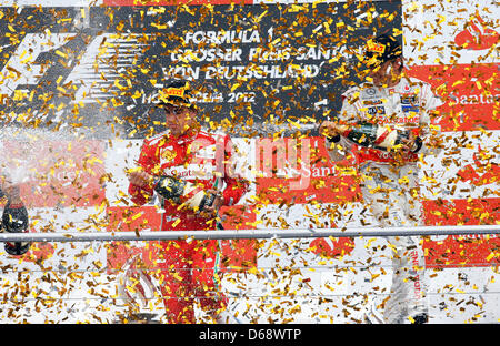 Il vincitore, Spagnolo di Formula Uno Pilota Fernando Alonso della Ferrari (L), celebra con thirdplaced British Jenson Button alla McLaren Mercedes sul podio dopo aver vinto il Gran Premio di Formula Uno di Germania a Hockenheim gara via di Hockenheim, in Germania, il 22 luglio 2012. Foto: Jens Buettner Foto Stock