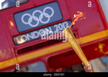 La torcia olimpica è portato di fronte ad un bus in Oxford Street a Londra, in Gran Bretagna, 26 luglio 2012. Il London 2012 Giochi Olimpici avranno inizio il 27 luglio 2012. Foto: Marius Becker dpa +++(c) dpa - Bildfunk+++ Foto Stock