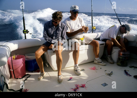 I pescatori scegliendo traina esche artificiali per la pesca nel golfo del Messico al largo da Port Aransas Texas Foto Stock