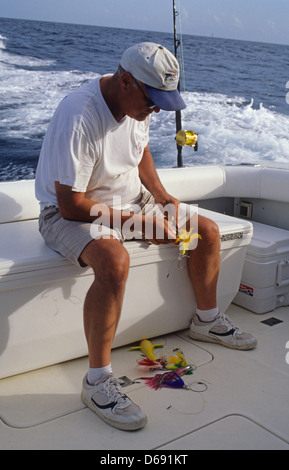 L'uomo scegliendo traina esche artificiali per la pesca nel golfo del Messico al largo da Port Aransas Texas Foto Stock