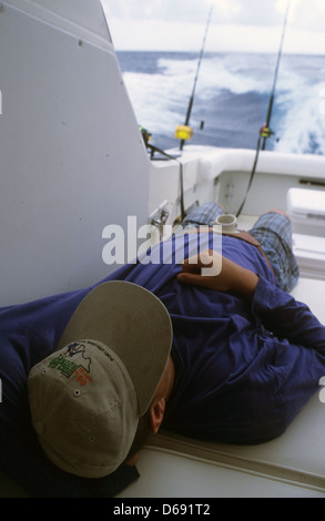 Fisherman prendendo un pisolino mentre trolling e pesca nel golfo del Messico al largo da Port Aransas Texas Foto Stock