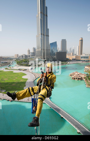 Detergenti per finestre la discesa in corda doppia verso il basso ad alto edificio di appartamenti in Dubai Emirati Arabi Uniti Foto Stock
