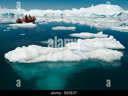 Un Inuit manzi una barca con i turisti tra gli iceberg nel fiordo di Sermilik nei pressi dei cacciatori Tiniteqilaaq insediamento sulla Groenlandia, Danimarca, 17 luglio 2012. Foto: Patrick Pleul Foto Stock