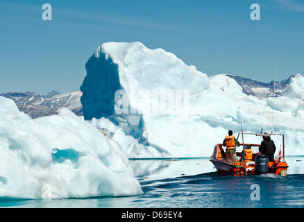 Un Inuit manzi una barca con i turisti tra gli iceberg nel fiordo di Sermilik nei pressi dei cacciatori Tiniteqilaaq insediamento sulla Groenlandia, Danimarca, 17 luglio 2012. Foto: Patrick Pleul Foto Stock