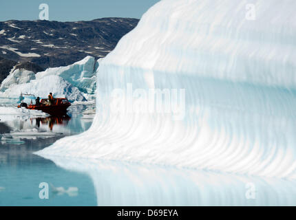 Un Inuit manzi una barca con i turisti tra gli iceberg nel fiordo di Sermilik nei pressi dei cacciatori Tiniteqilaaq insediamento sulla Groenlandia, Danimarca, 17 luglio 2012. Foto: Patrick Pleul Foto Stock