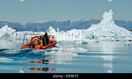 Un Inuit manzi una barca con i turisti tra gli iceberg nel fiordo di Sermilik nei pressi dei cacciatori Tiniteqilaaq insediamento sulla Groenlandia, Danimarca, 17 luglio 2012. Foto: Patrick Pleul Foto Stock