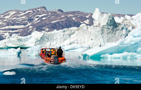 Un Inuit manzi una barca con i turisti tra gli iceberg nel fiordo di Sermilik nei pressi dei cacciatori Tiniteqilaaq insediamento sulla Groenlandia, Danimarca, 17 luglio 2012. Foto: Patrick Pleul Foto Stock