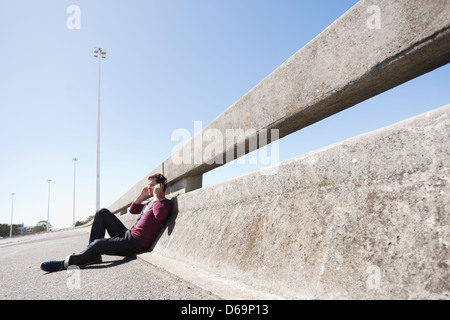 Uomo che indossa le cuffie sulla strada di città Foto Stock