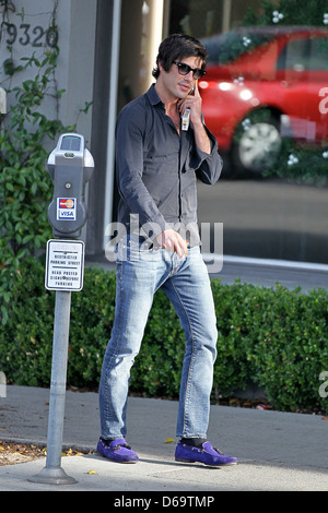 Brandon Davis fumatori e parlando sul suo telefono cellulare in Beverly Hills Los Angeles, California - 28.11.11 Foto Stock