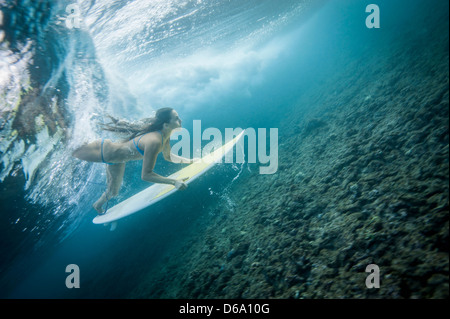 Surfer immersioni subacquee in onda in acqua Foto Stock