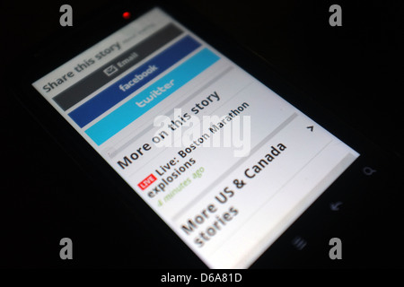 Un telefono cellulare schermo che mostra i tweet seguendo le esplosioni che hanno colpito la Maratona di Boston il 15 aprile 2013. Foto Stock