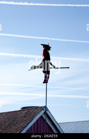 Strega e Ginestra in Pole attaccata al tetto del granaio con aereo sentieri nel cielo Foto Stock