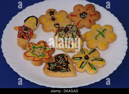 Biscotti fatti in casa con decorazioni su una piastra bianca Foto Stock