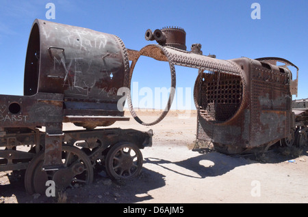 Una vecchia locomotiva a vapore arrugginimento lontano nel treno cimitero vicino Uyuni, Bolivia Foto Stock