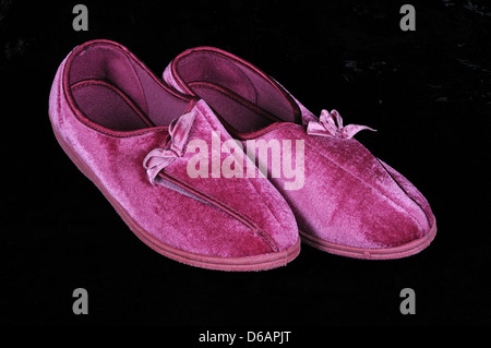 Womans deep pink pantofole contro uno sfondo nero. Foto Stock